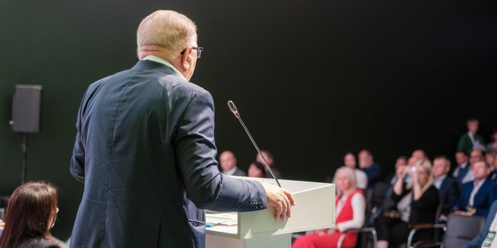 Well dressed man standing at a podium